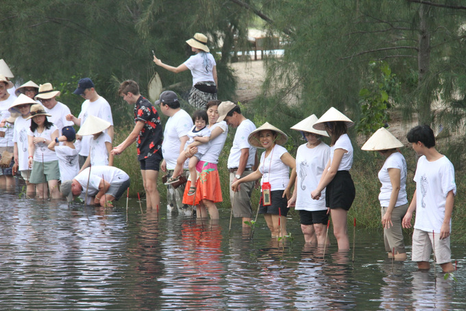 Du khách trồng cây đước xuống đầm trong khuôn viên khu nghỉ dưỡng