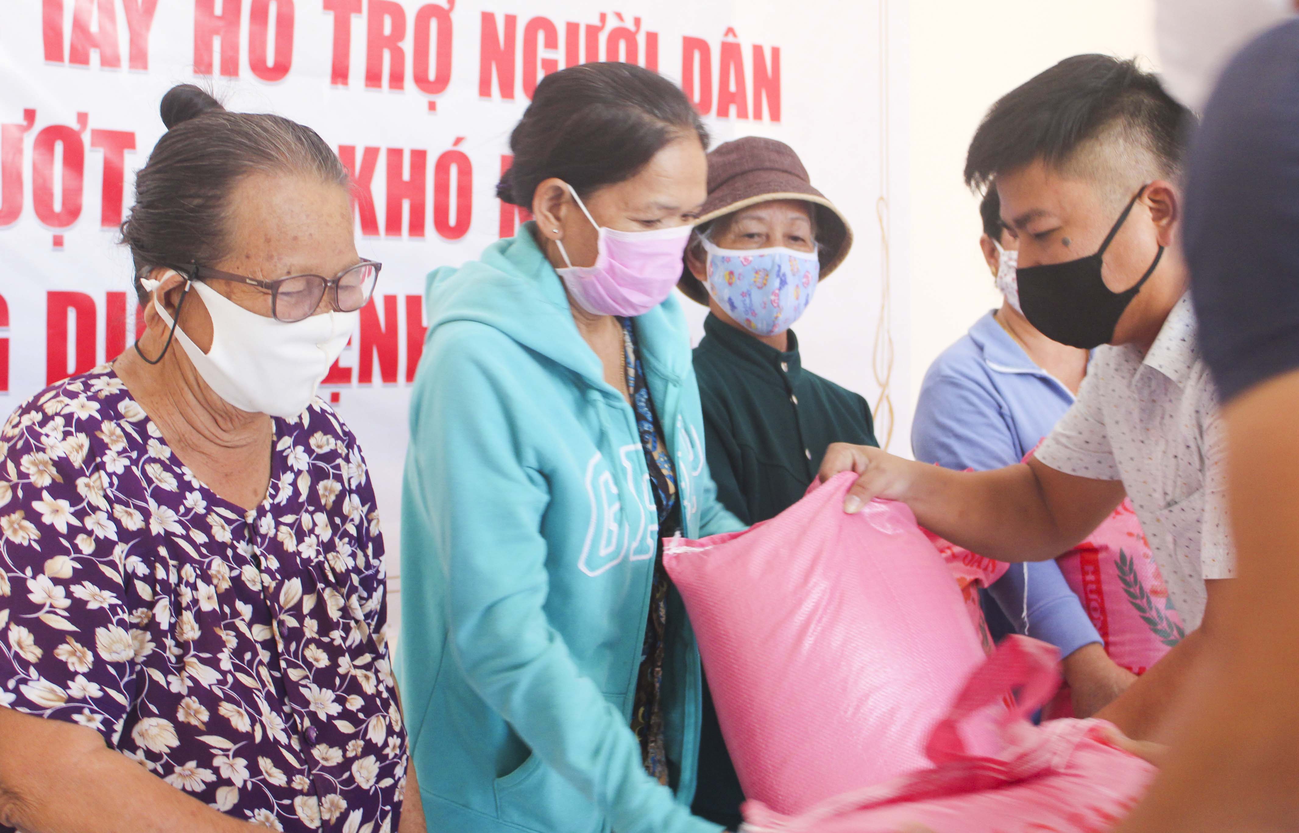 Công ty Cổ phần Xây dựng – Thương mại và Dịch vụ Đồng Nguyên trao tận tay phần gạo cho người dân