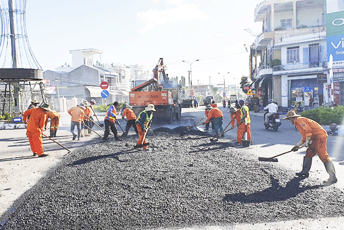 Thi công khắc phục hư hỏng Quốc lộ 1 tại thị trấn Vạn Giã (ảnh chụp ngày 18-11).