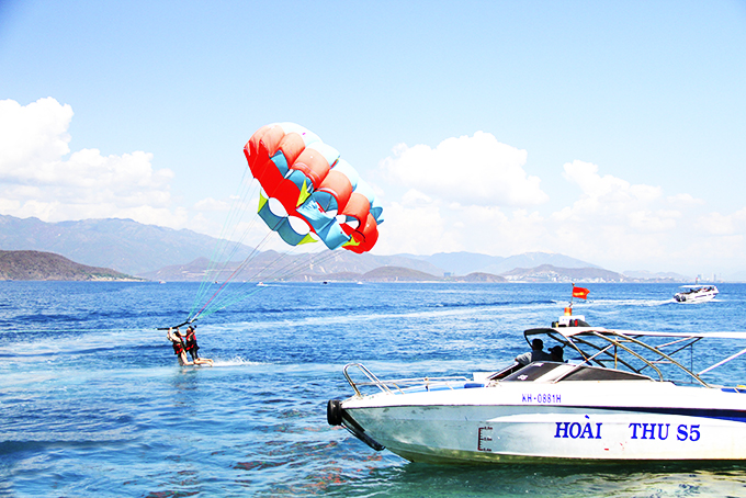 Du khách chơi dù kéo trên vịnh Nha Trang.