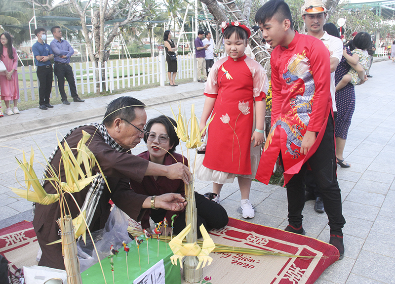 Các em nhỏ thích thú xem nghệ nhân tạo hình các con vật từ lá dừa