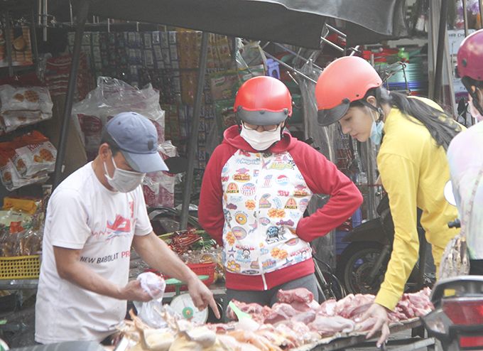 Tiểu thương tại chợ Xóm Mới (Tp. Nha Trang) đang bán hàng cho khác (ảnh chụp chiều 2-7)