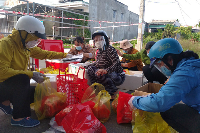 Cán bộ, hội viên Hội Liên hiệp Phụ nữ huyện Vạn Ninh hỗ trợ thực phẩm cho người dân trong khu phong tỏa trên địa bàn thị trấn Vạn Giã. Ảnh: MẠNH HÙNG