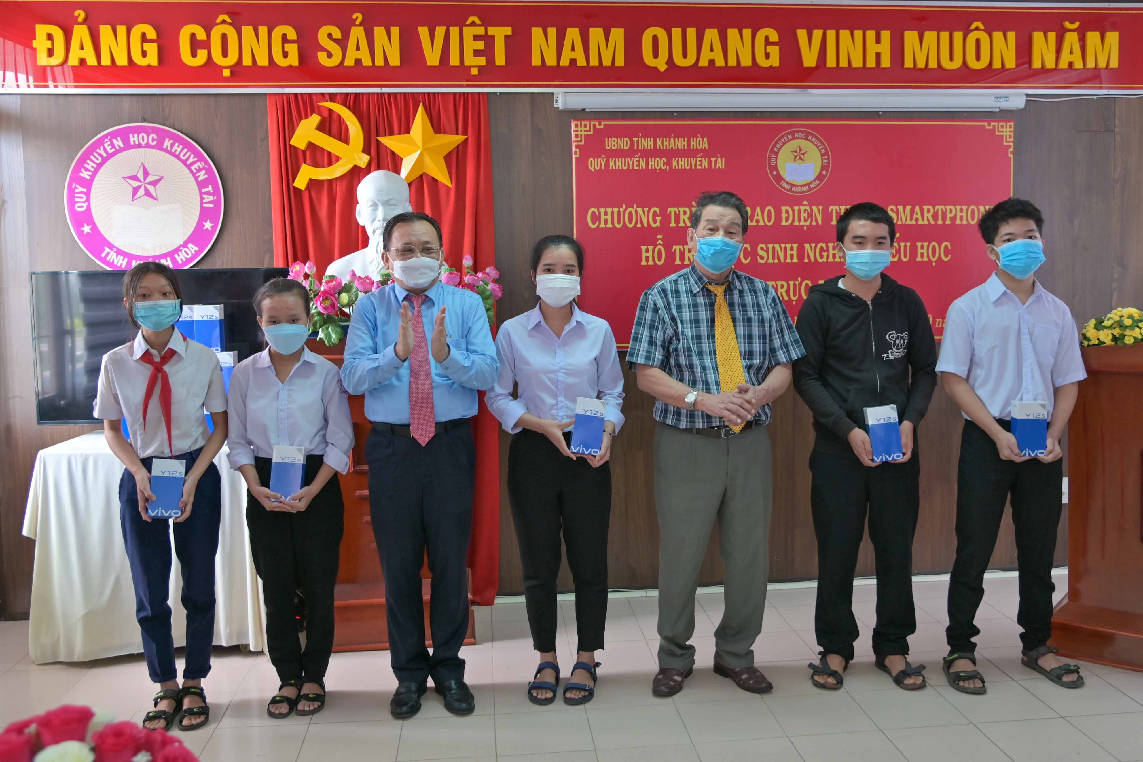 Ông Lê Hữu Hoàng và lãnh đạo Quỹ Khuyến học, khuyến tài tỉnh trao điện thoại cho các học sinh