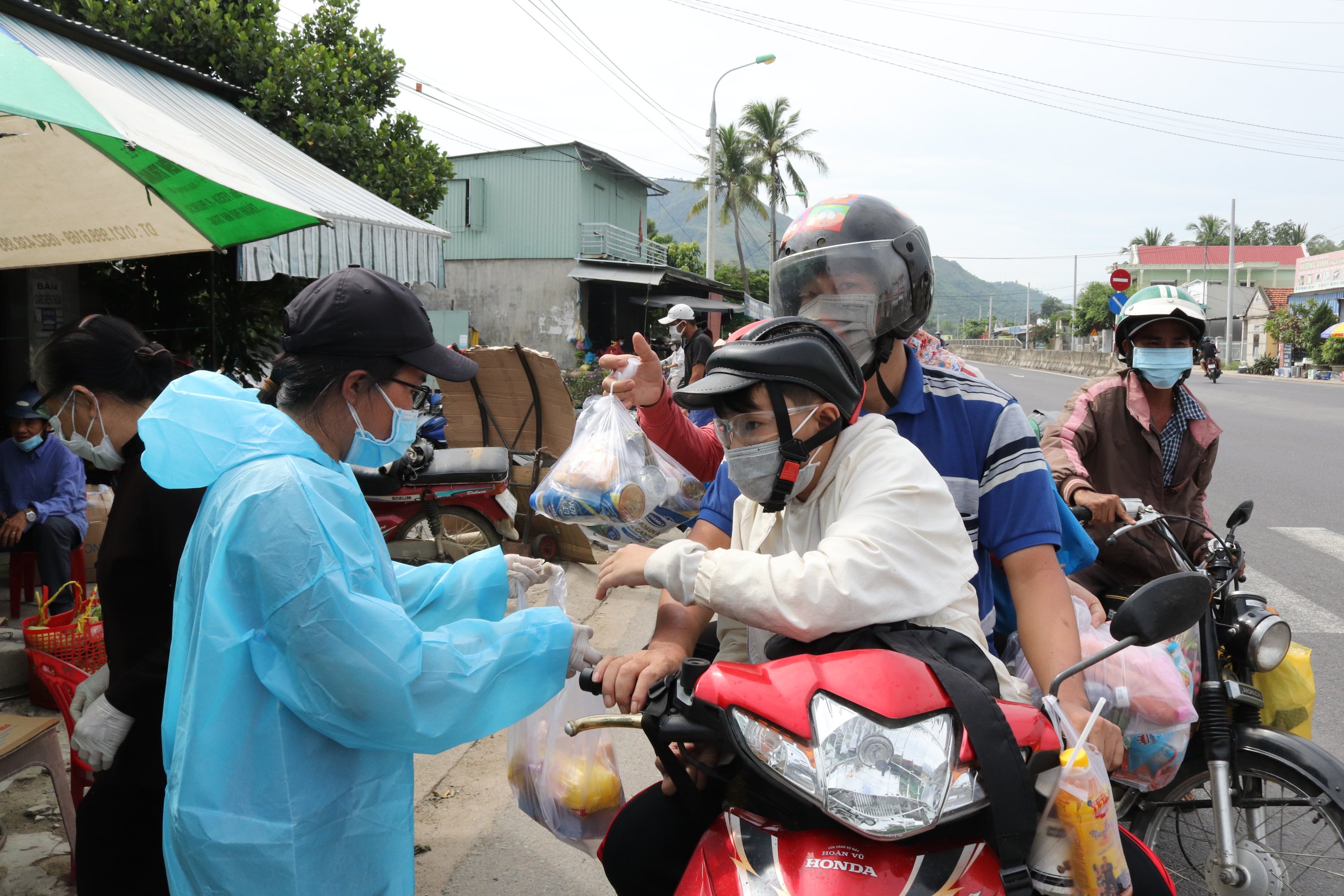 Người dân tặng nước, bánh, cơm hộp cho những người lao động về quê.