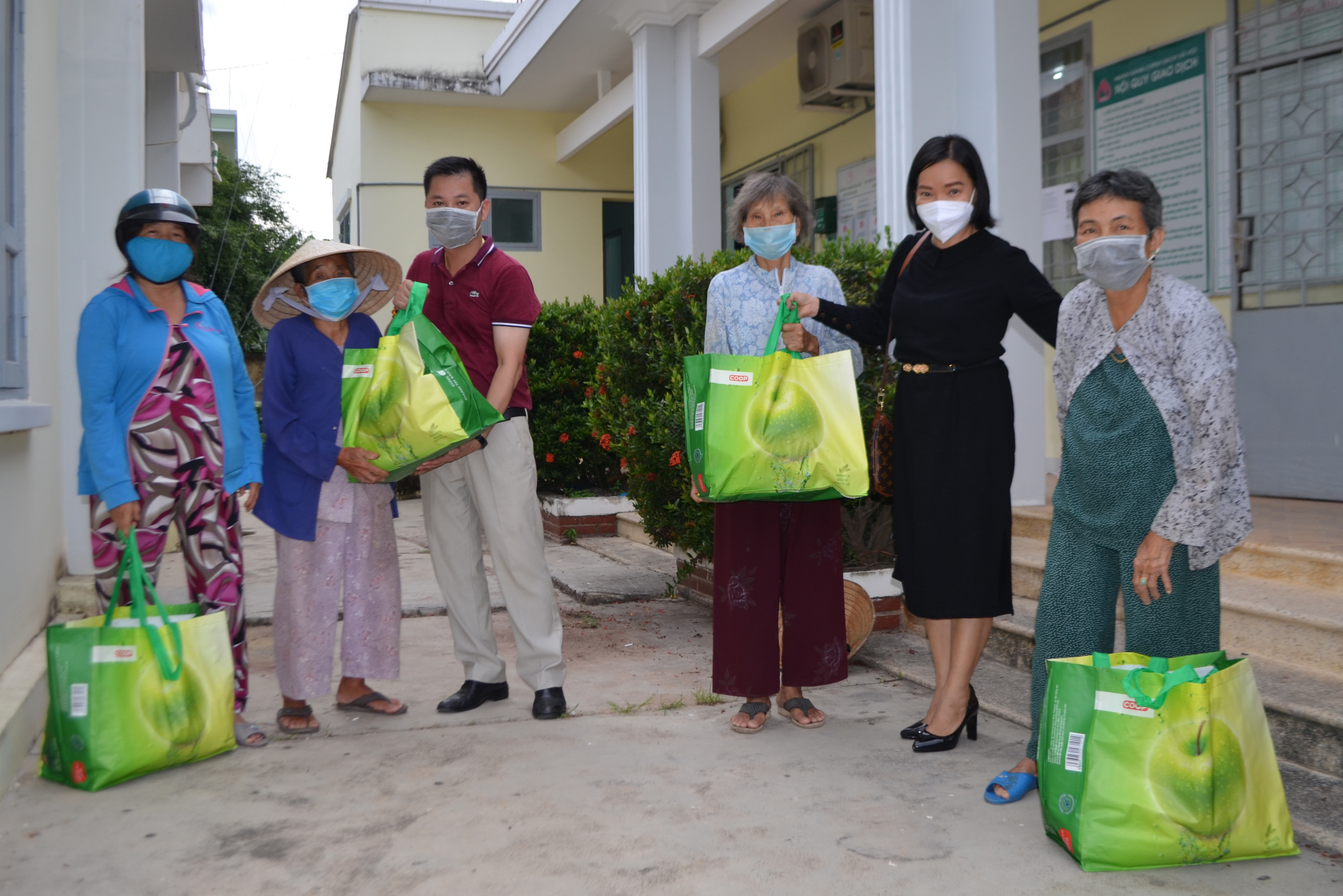 Bà Thái Thị Lệ Hằng- Phó Tổng Biên tập Báo Khánh Hòa và ông Huỳnh Đức Hòa - Tổng giám đốc Công ty Cổ phần Dịch vụ Y tế Bondtech Việt Nam  trao quà cho người dân xã Bình Lộc, huyện Diên Khánh