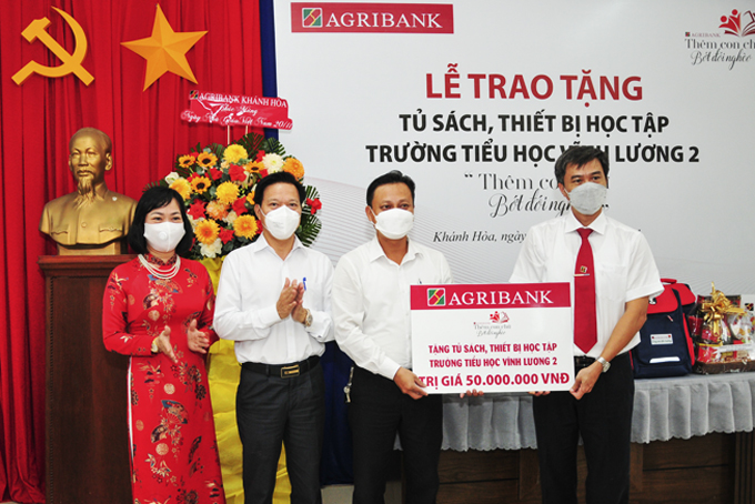 Lãnh đạo Agribank Chi nhánh tỉnh Khánh Hòa (bìa phải)  trao biểu trưng hỗ trợ cho Trường Tiểu học Vĩnh Lương 2.