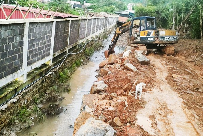 Một phần diện tích đất lấn chiếm mương nước đang được người vi phạm múc đất đá lên trả lại nguyên trạng ban đầu. Ảnh: Thành Nam