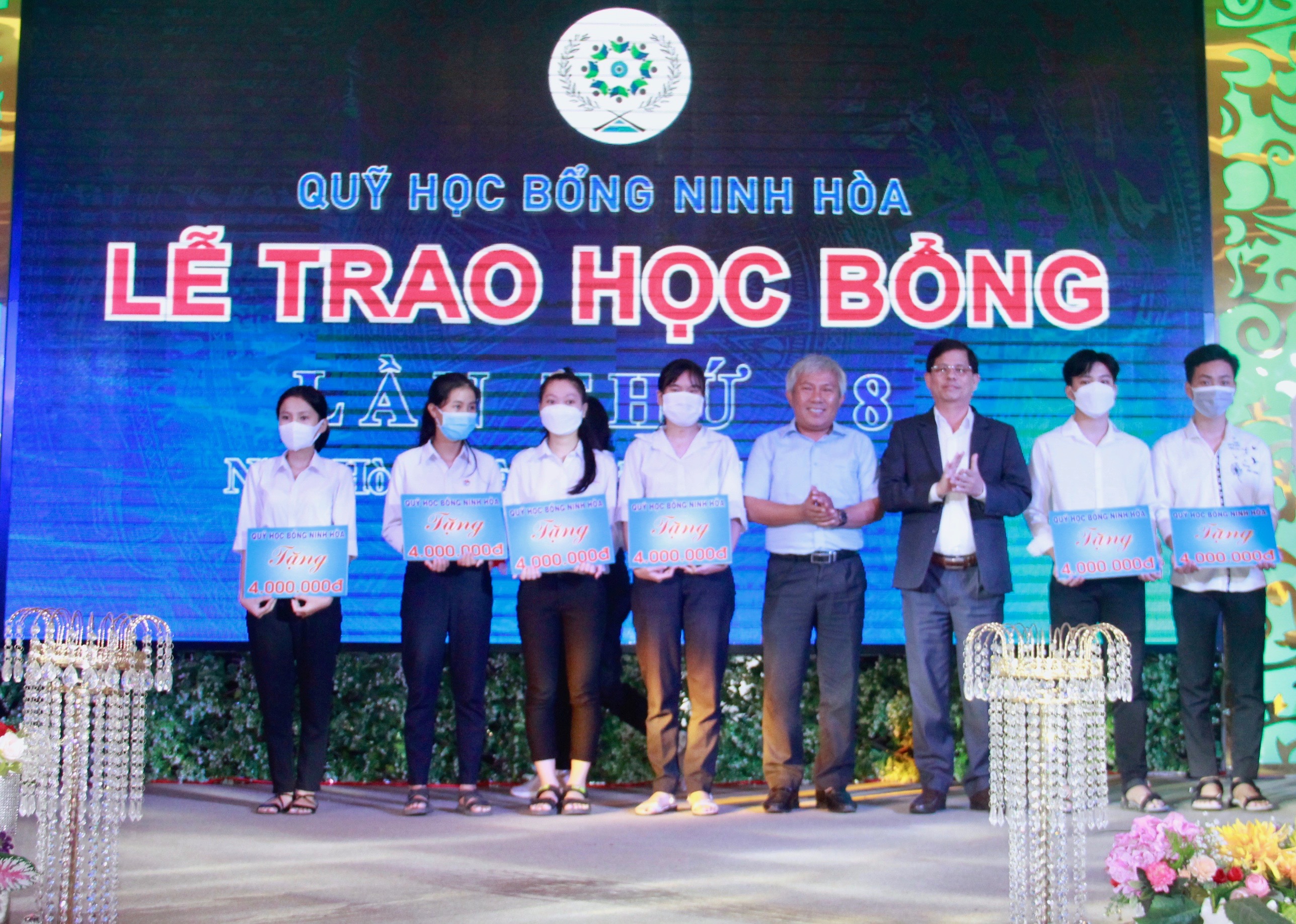 Ông Nguyễn Tấn Tuân (thứ 3 từ phải sang) trao học bổng cho các sinh viên có hoàn cảnh khó khăn