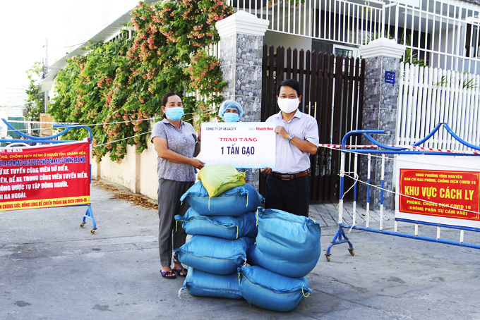 Ông Trần Duy Hưng - Tổng Biên tập Báo Khánh Hòa trao quà hỗ trợ  của Công ty Cổ phần Vega City cho người dân phường Vĩnh Nguyên ngày 26-7.