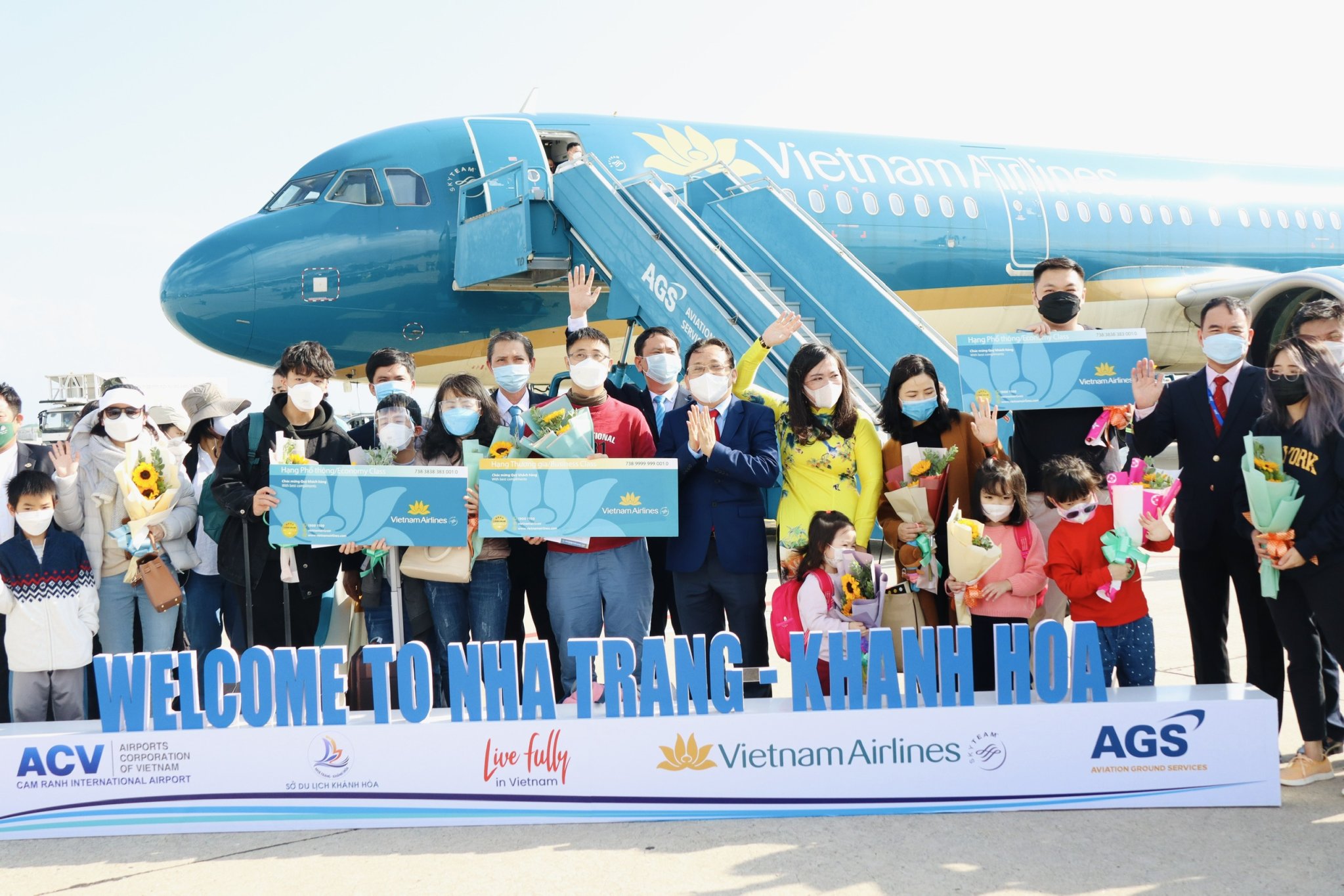 Ông Lê Hữu Hoàng cùng lãnh đạo Sở Du lịch, Hiệp hội Du lịch, Cảng HKQT Cam Ranh, Vietnam Airlines chi nhánh Nha Trang... tặng quà cho những vị khách đầu tiên đến Khánh Hòa trong năm Nhâm Dần 2022