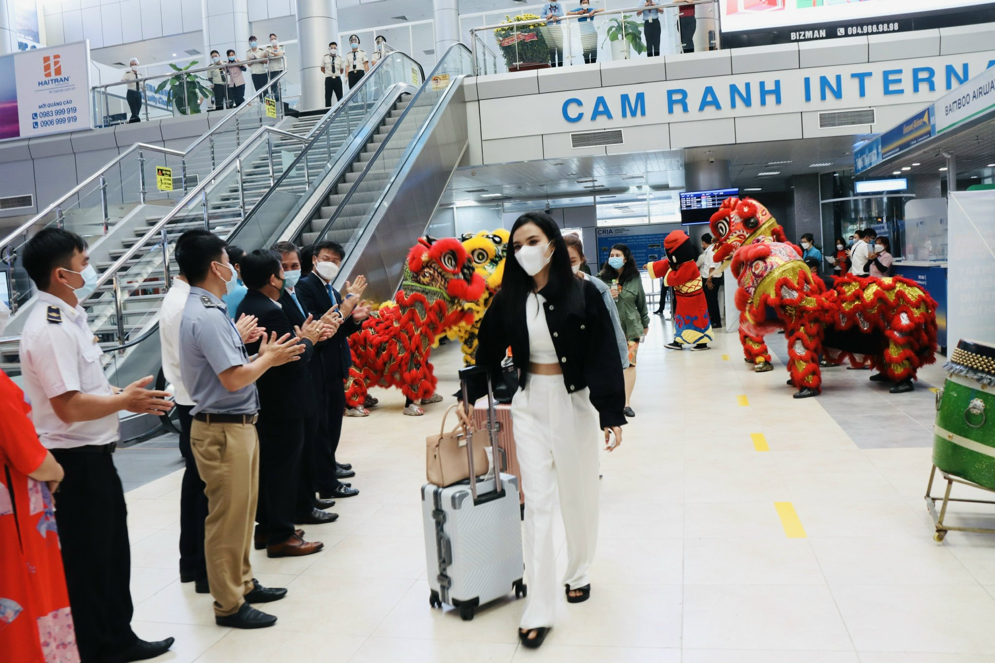 Khách du lịch đi qua Nhà ga nội địa sân bay quốc tế Cam Ranh trong sự chào mừng của đội lân và các đại biểu