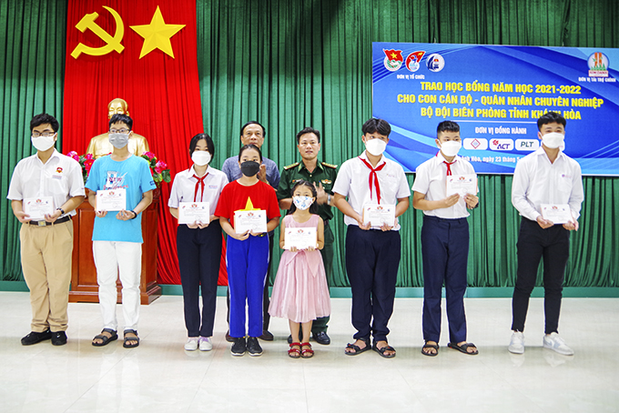 Đại tá Trần Quốc Toản - Chỉ huy trưởng Bộ đội Biên phòng tỉnh  và ông Nguyễn Trân Châu - Phó Giám đốc Quỹ học bổng Vừ A Dính  trao học bổng cho học sinh.