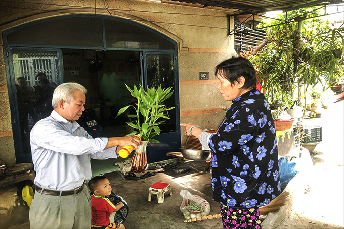 Đoàn kiểm tra hướng dẫn người dân nhỏ nước rửa chén vào bình hoa để diệt lăng quăng.