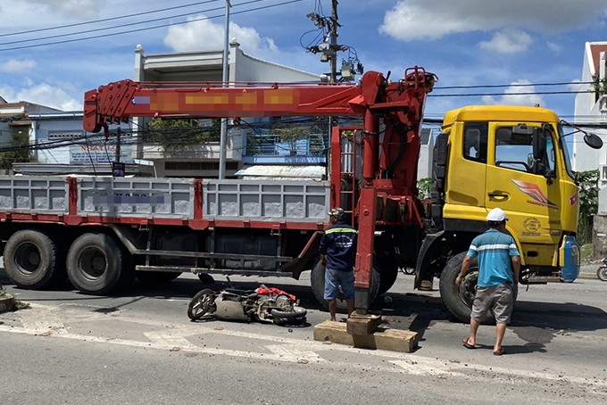 Xe máy tan nát được các kéo ra từ bánh xe tải.