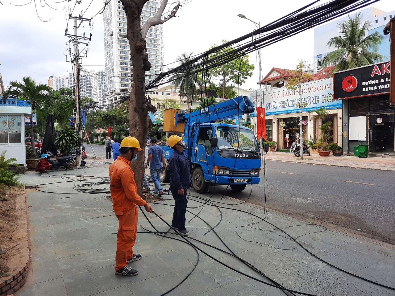 Công nhân điện lực xử lý, thu hồi cáp viễn thông treo trên cột điện tại Diên Khánh