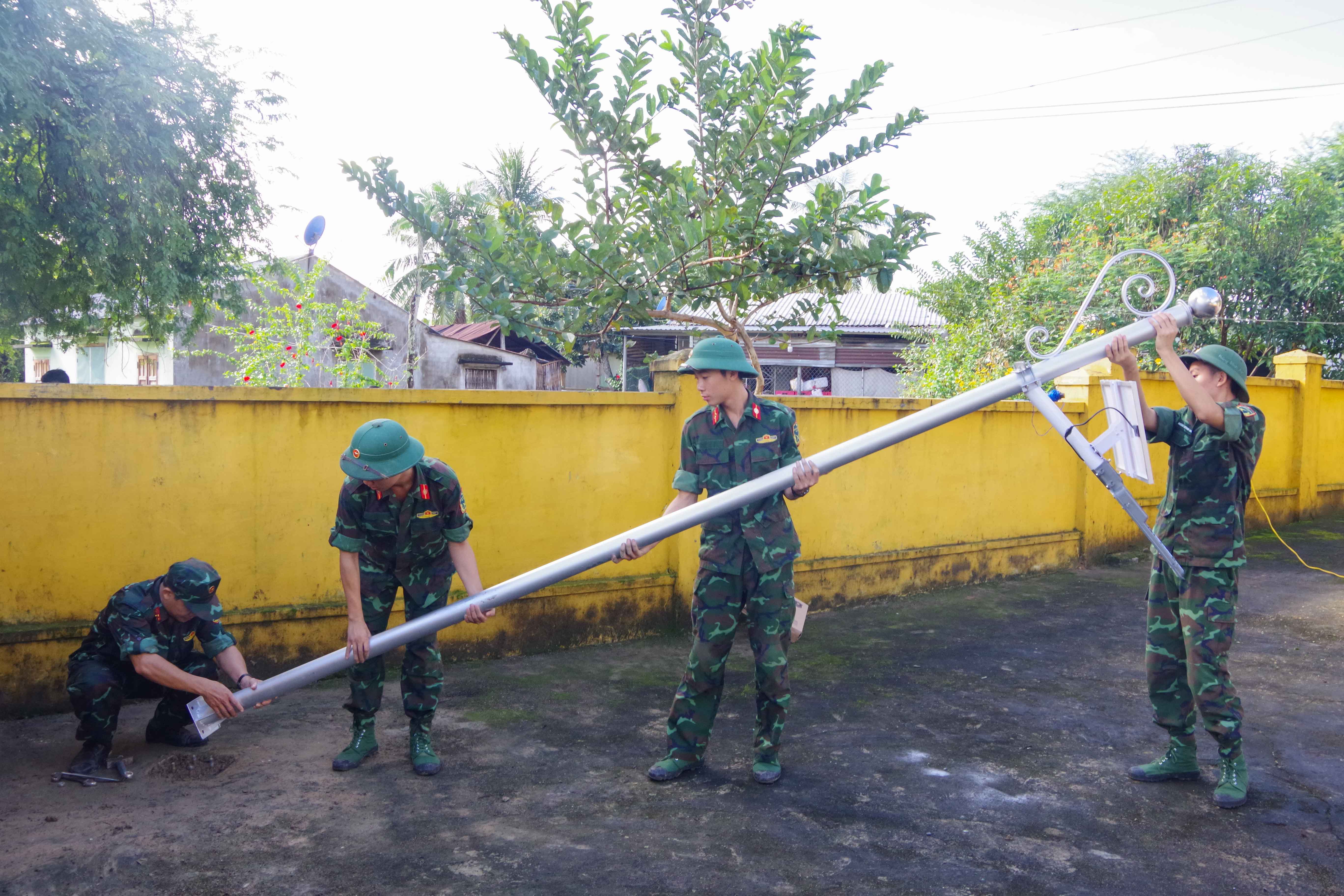 Các đoàn viên, thanh niên lắp đặt đèn năng lượng mặt trời tại đài tưởng niệm các anh hùng liệt sĩ của xã