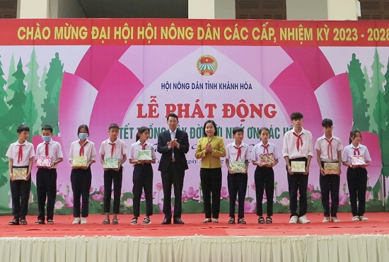 Ông Đinh Văn Thiệu và lãnh đạo Hội Nông dân tỉnh trao quà cho các học sinh. 