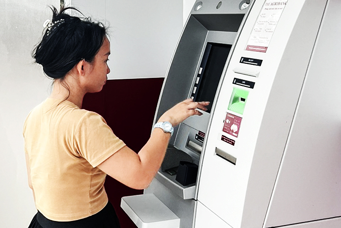 Người dân rút tiền tại trụ ATM ở thị trấn Khánh Vĩnh. Ảnh: Thế Tài