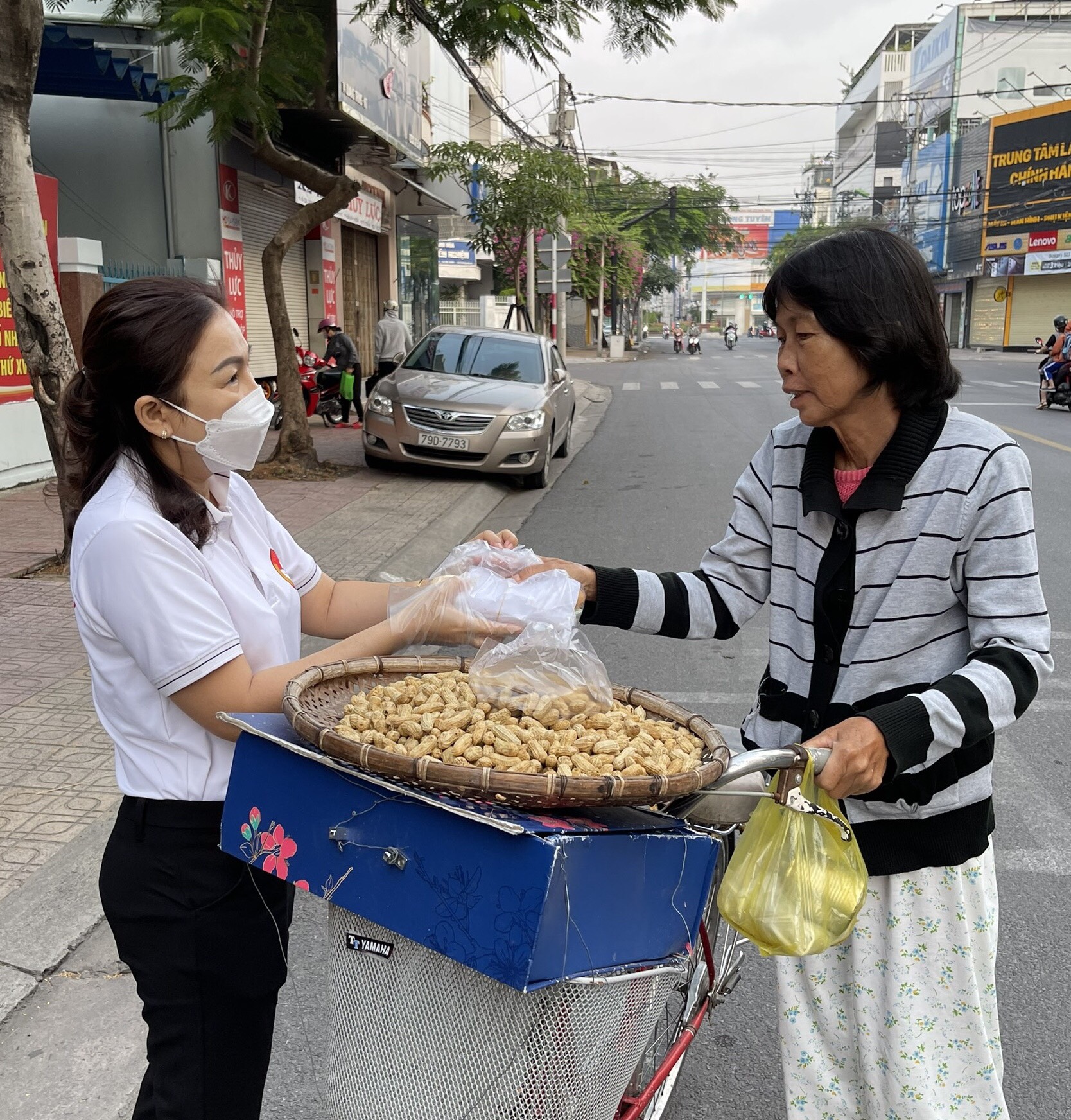 Bà Nguyễn Thị Cẩm Nhung - Chủ tịch UBMTTQ Việt Nam phường Vạn Thắng trao bữa ăn sáng cho một lao động nghèo.