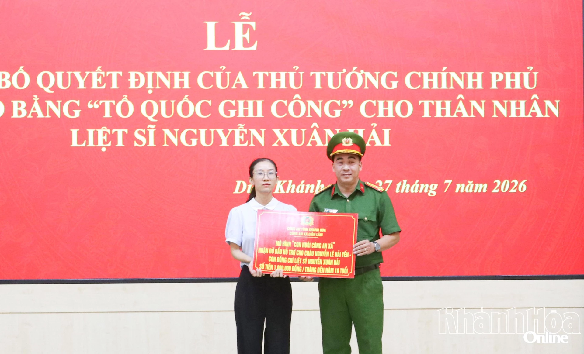 Công an xã Diên Lâm trao bảng tượng trưng mô hình “Con nuôi công an xã” cho thân nhân liệt sĩ Nguyễn Xuân Hải. 