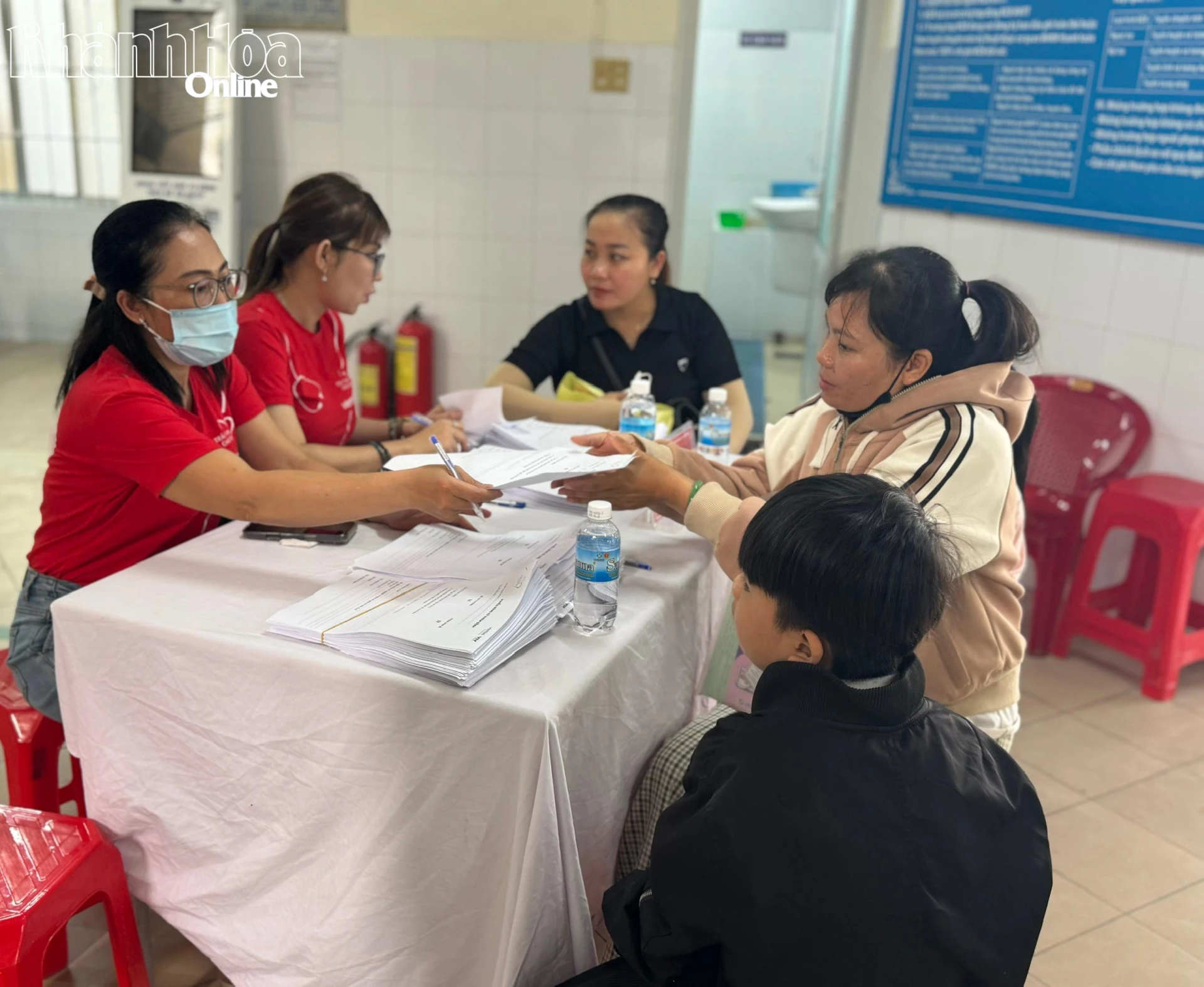 Đội ngũ chương trình ghi thông tin và trao số thứ tự cho trẻ đến khám sàng lọc.