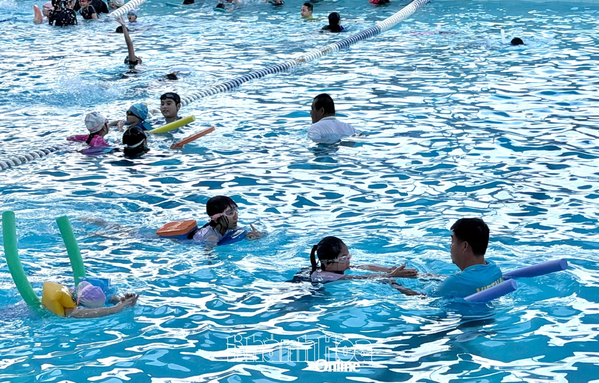 Học viên nhí được giáo viên hướng dẫn kỹ năng bơi.