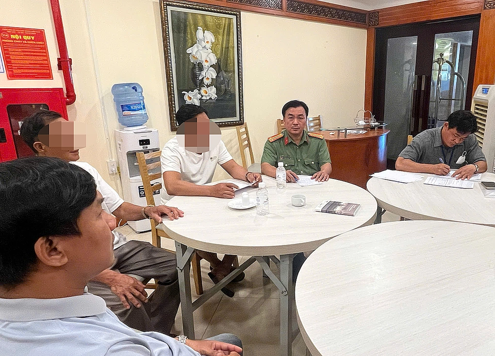 Lực lượng chức năng làm việc với hai du khách bẻ san hô ở biển Hòn Chồng. Ảnh: Minh Khuê